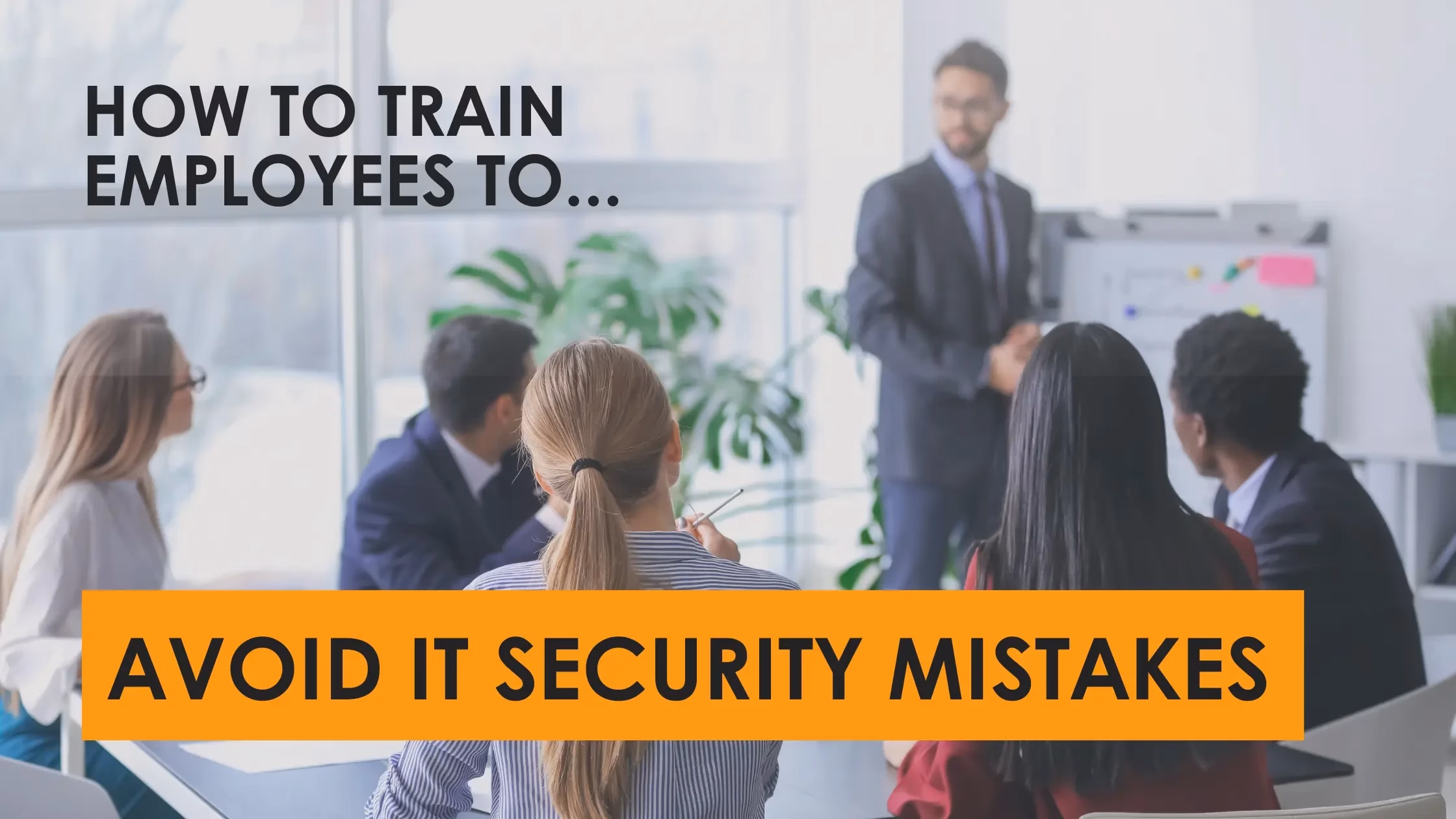 Man presenting cybersecurity training to office employees in a modern workplace; digital shield icon on screen with the text “How to Train Employees to Avoid IT Security Mistakes”